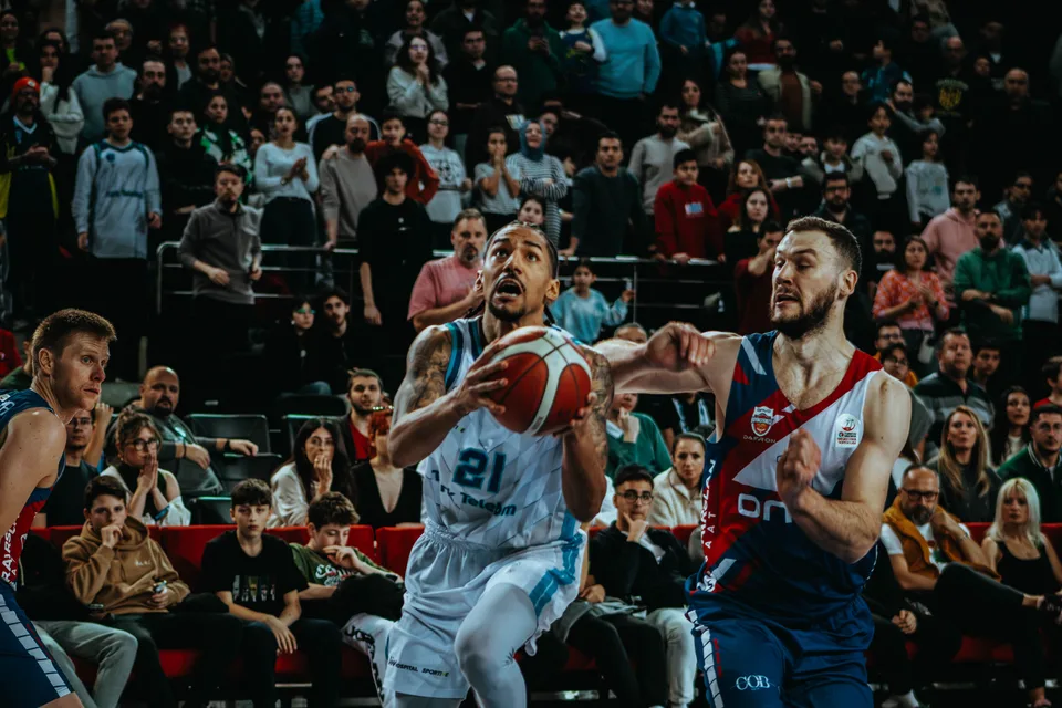 An intense basketball game action shot capturing players in mid-play.