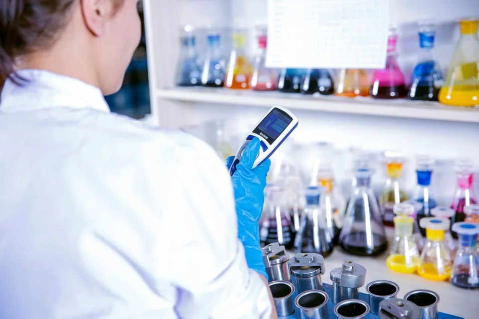 A laboratory chemist using an electronic multichannel pipette for precise research work.