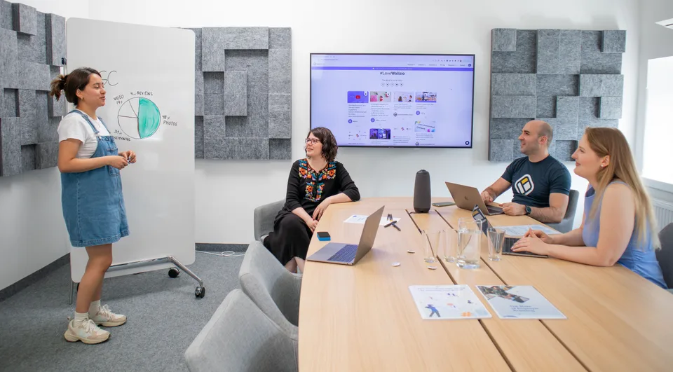A small creative team reviewing video content on screens in a bright office