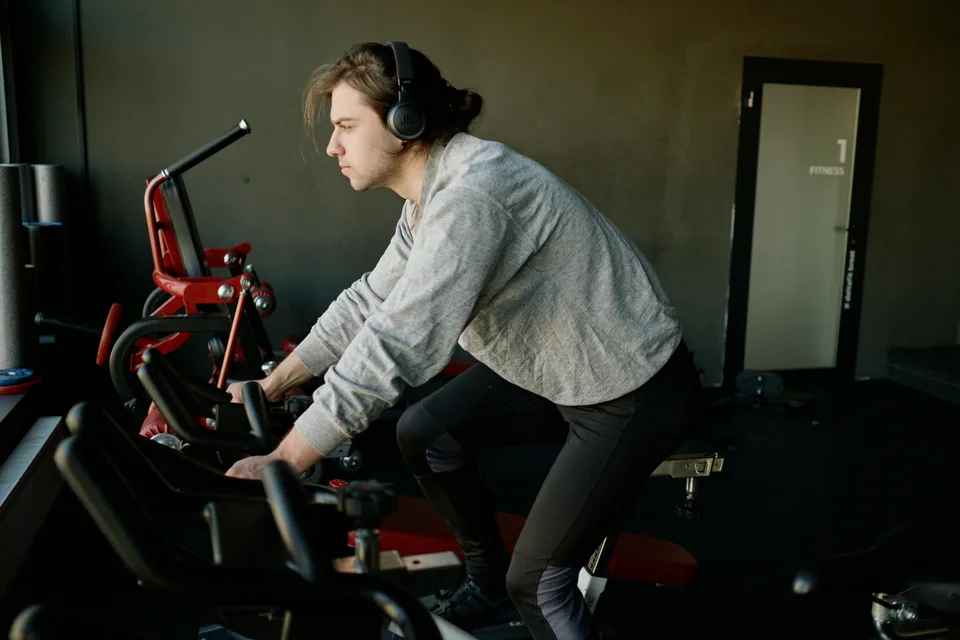A man training on a stationary exercise bike in a home or studio setting.