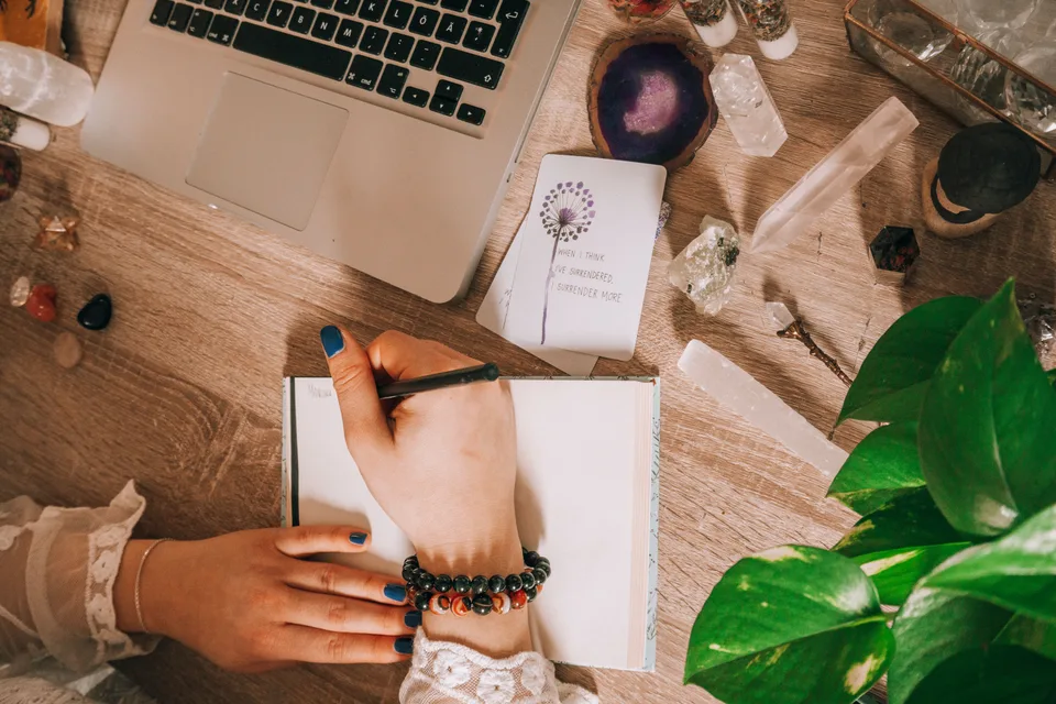 A close-up shot of a woman writing in a notebook, engaged in journaling.