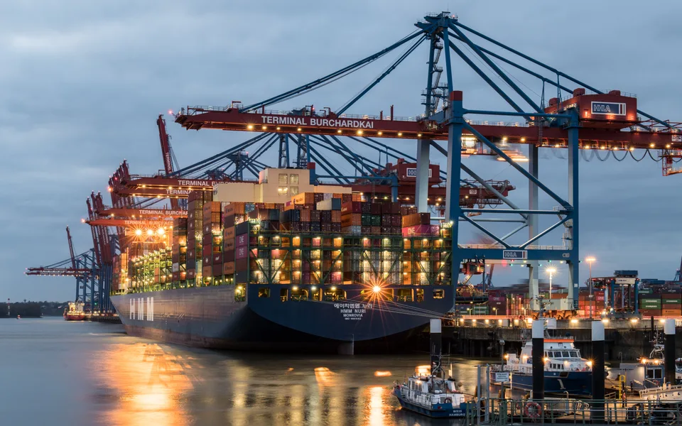 container ship being loaded with shipping containers at a port terminal