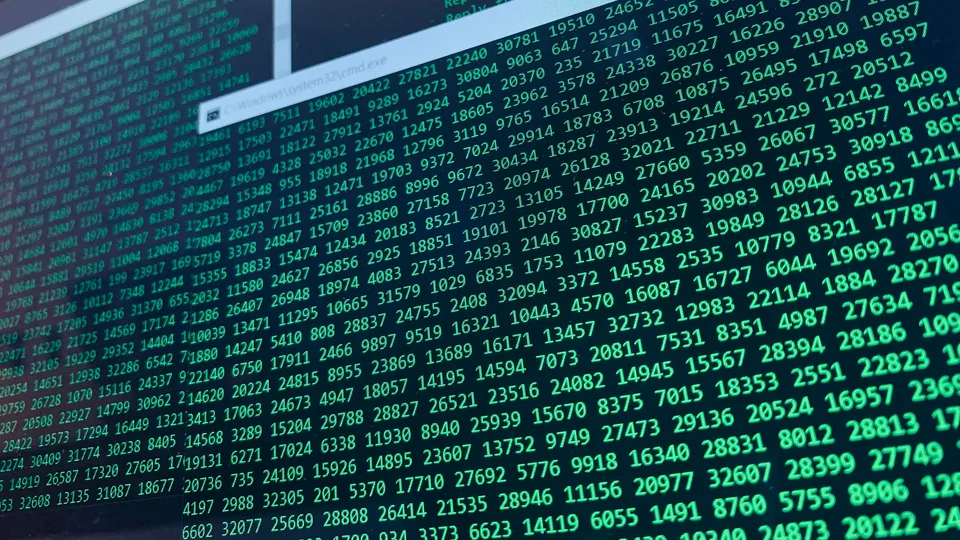 Lines of code displayed on a computer screen in a dimly lit setting.