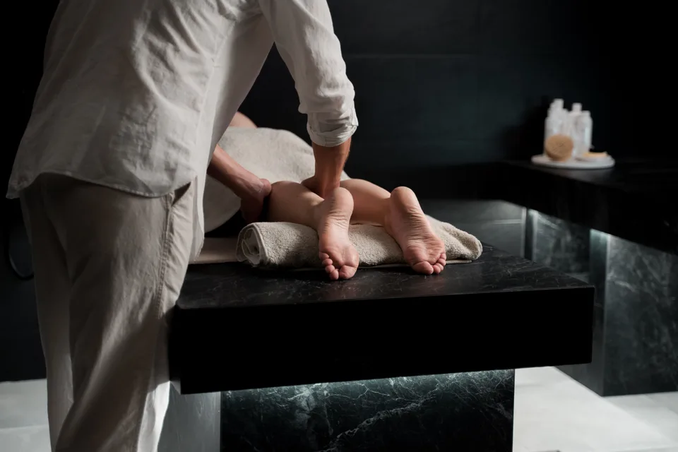 A person receiving a professional massage treatment, lying face-down on a treatment table.