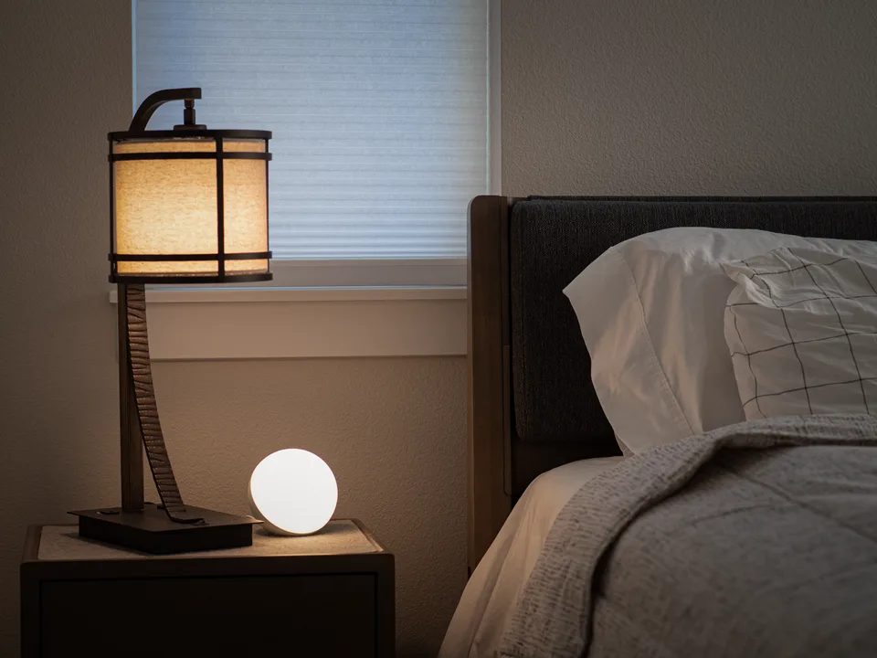 A cozy bedroom nightstand scene with warm lighting, set up for a peaceful night's sleep.