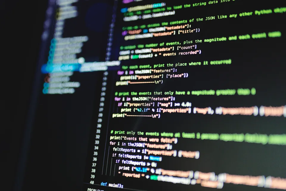 Close-up of colorful source code with line numbers on a dark computer monitor