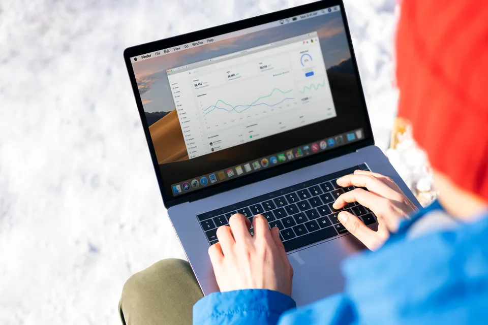 A person working on a black laptop displaying data and analytics.