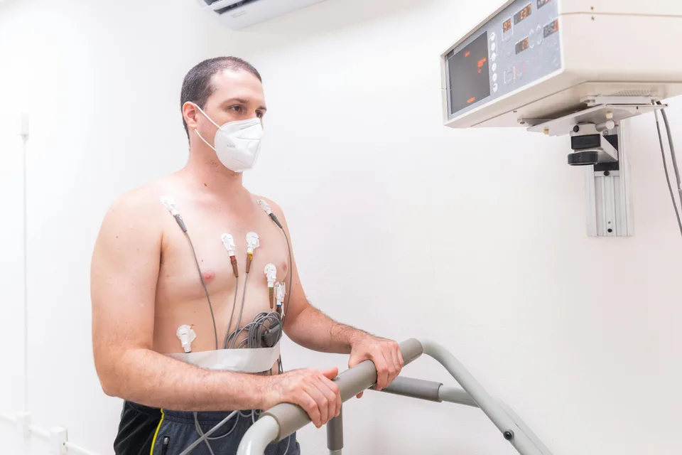 A patient wearing electrodes for a cardiac stress test in a clinical setting.