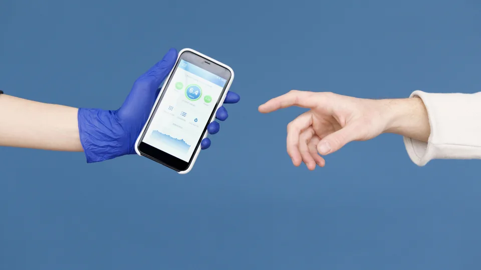 A person wearing latex gloves holding and interacting with a smartphone, in a clinical or health-related context.
